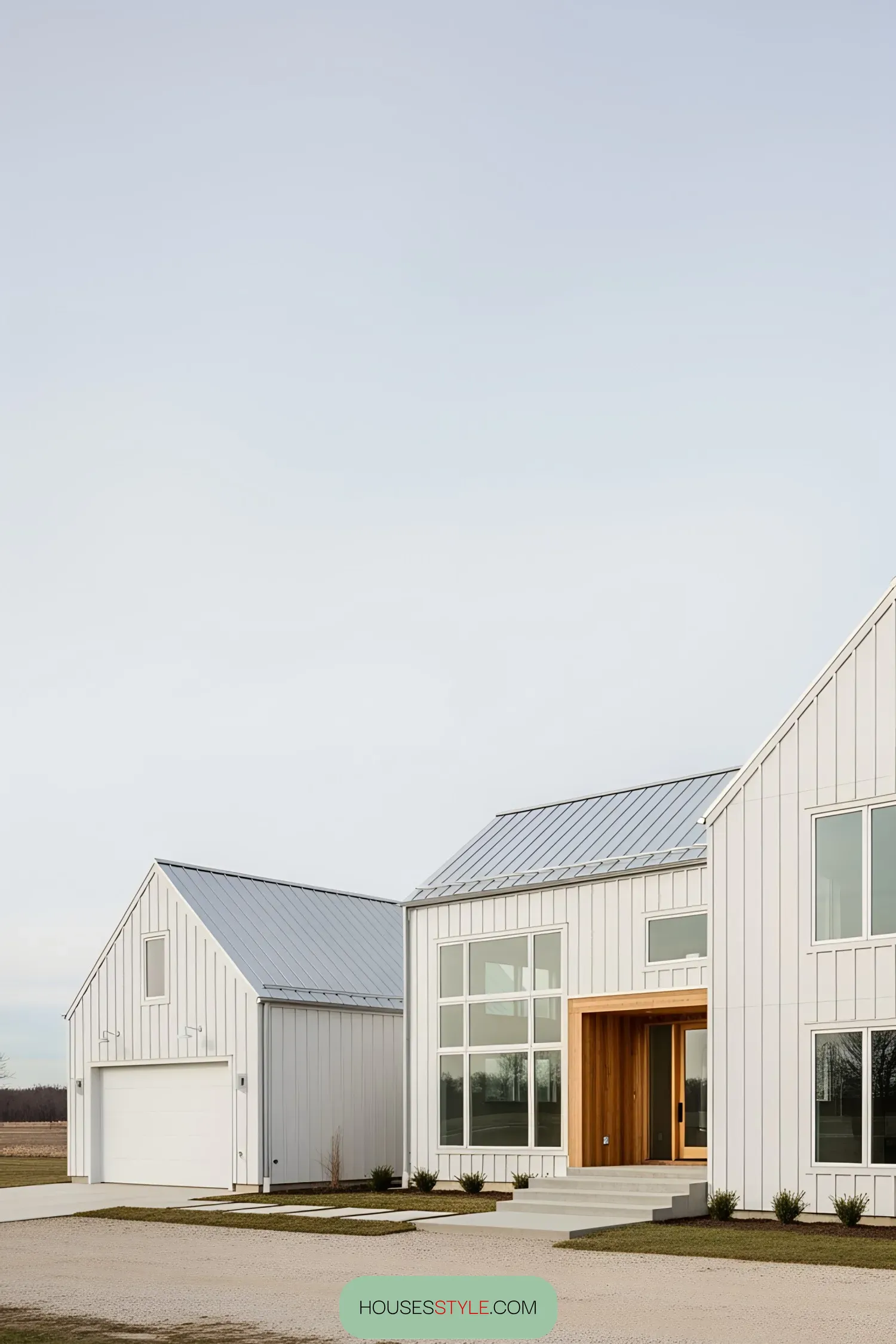 White farmhouse with a metal roof and attached garage