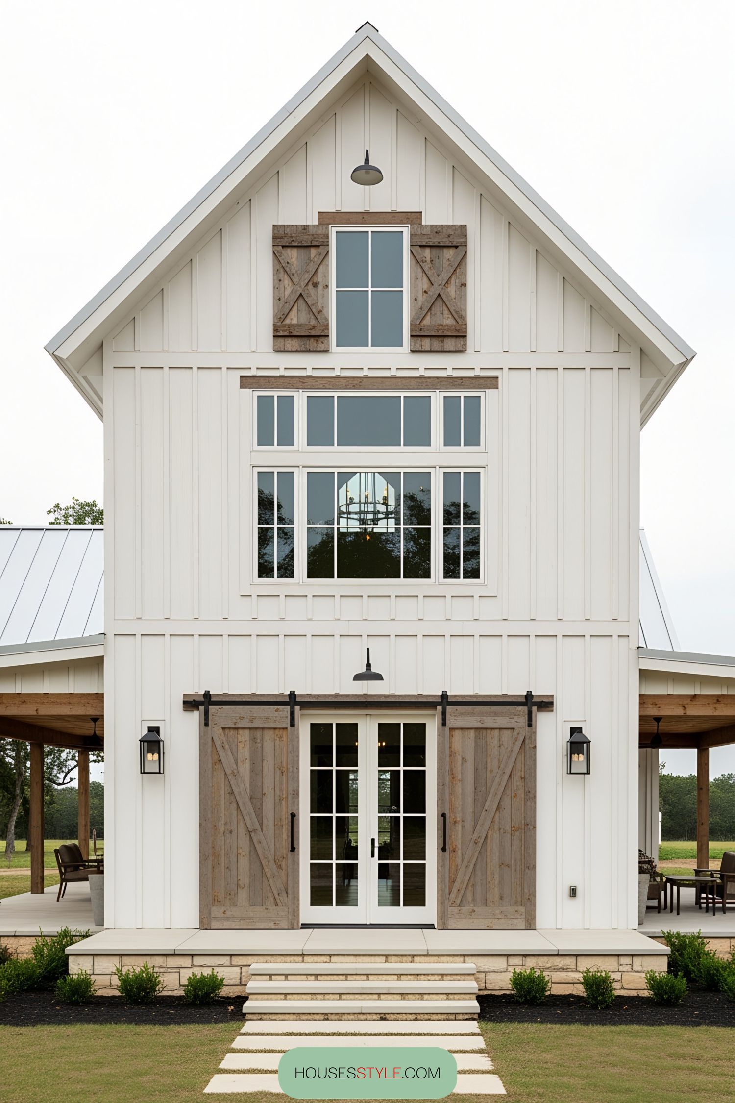 Front view of a white barn house with rustic wooden accents