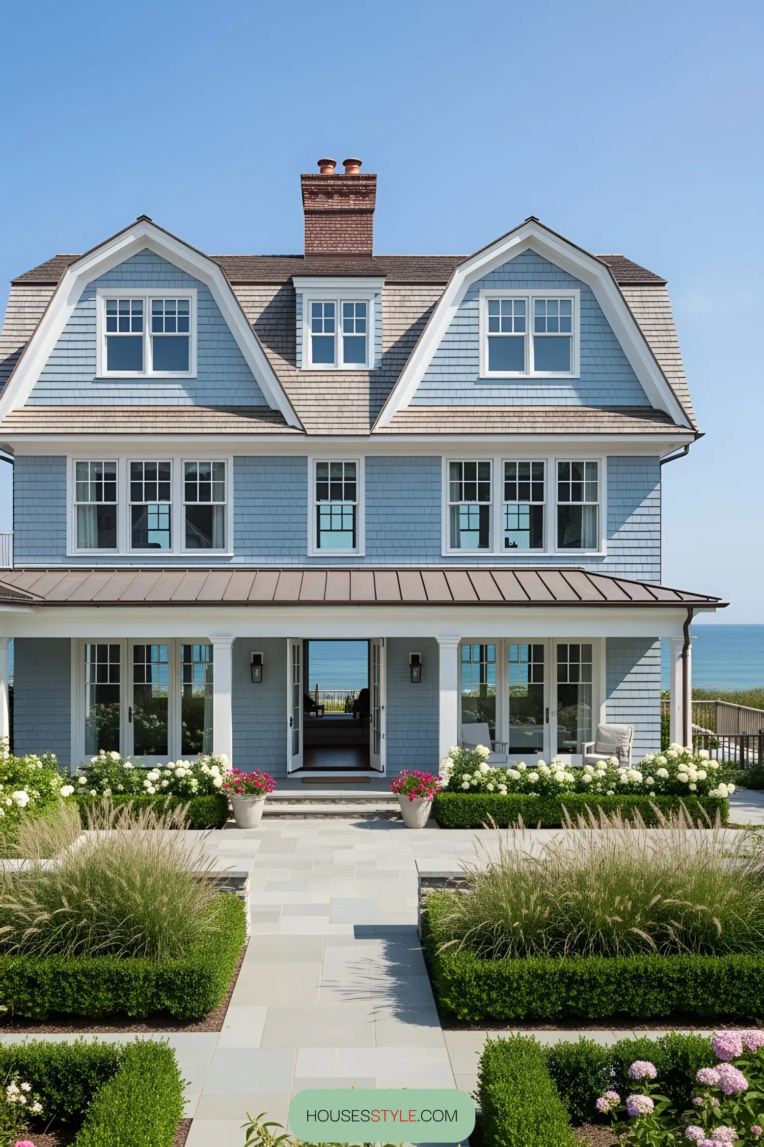 A stunning blue coastal house with a beautiful garden