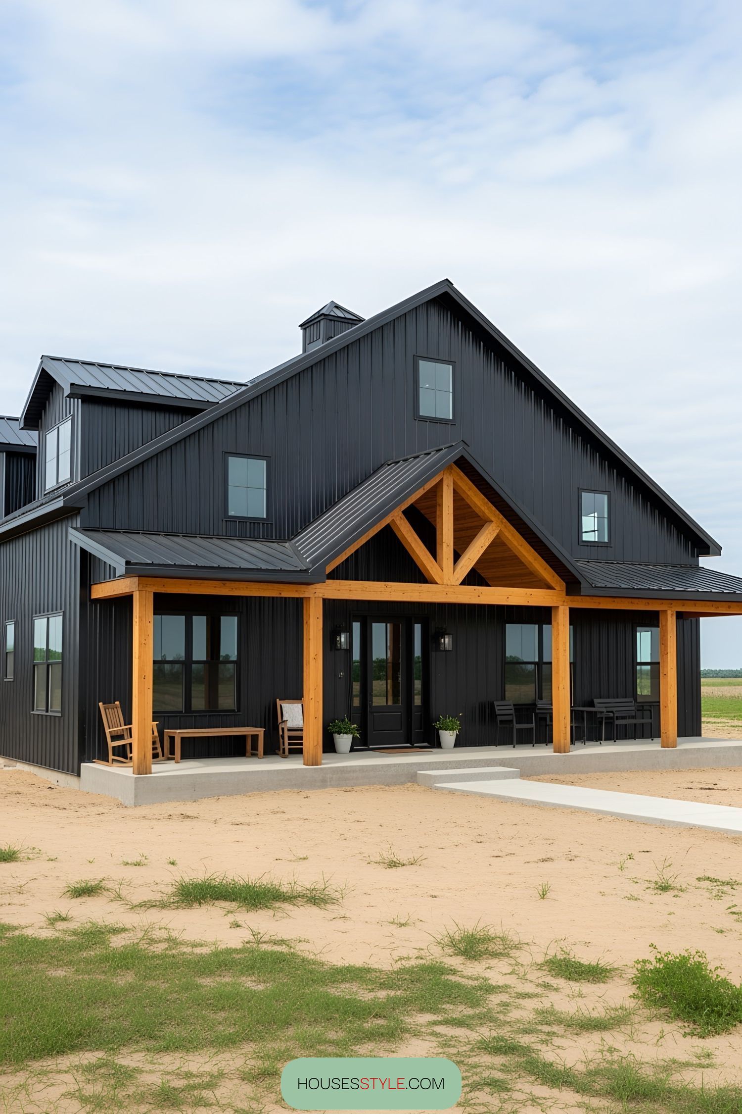 Black barn house with wood accents and clear sky