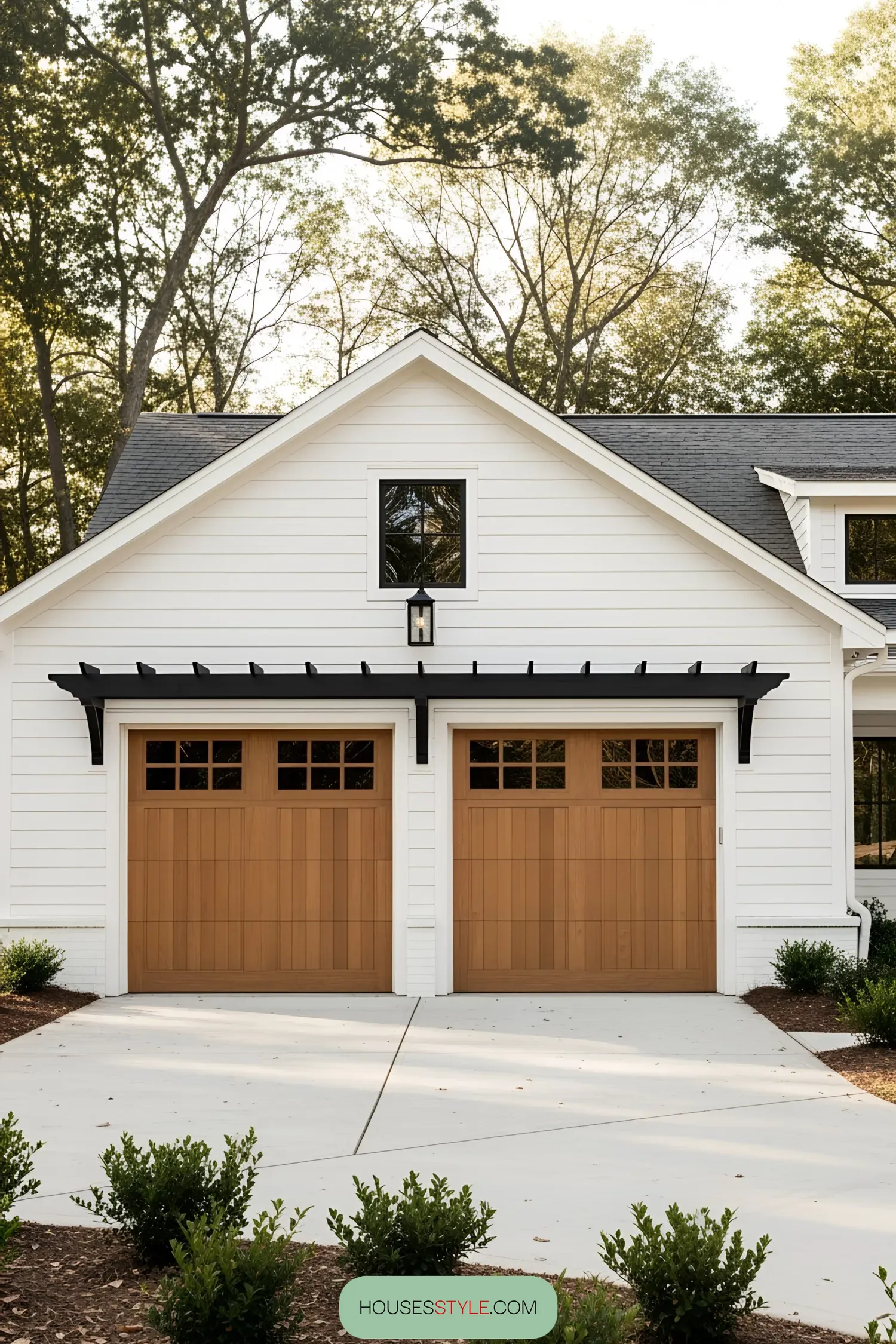 White farmhouse with twin wooden garage doors