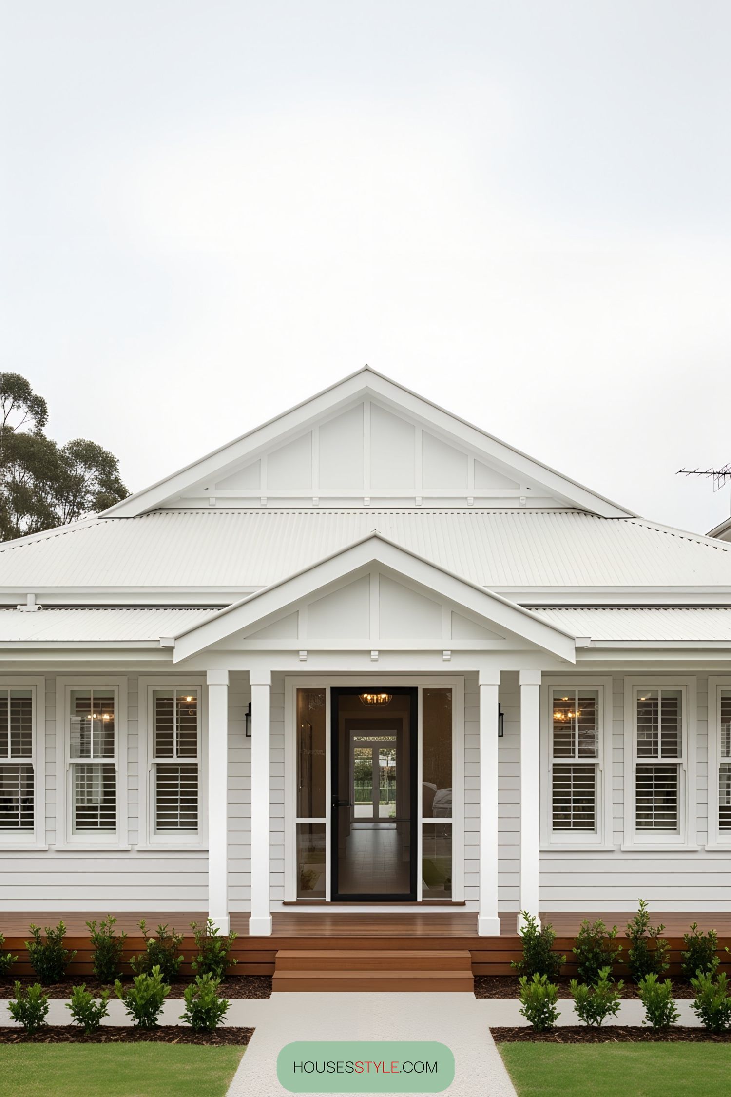Crisp white bungalow with a cozy porch and vibrant greenery