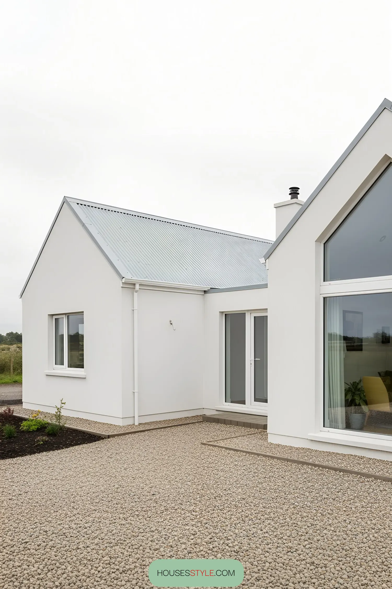 Modern white bungalow with glass doors and pebbled path