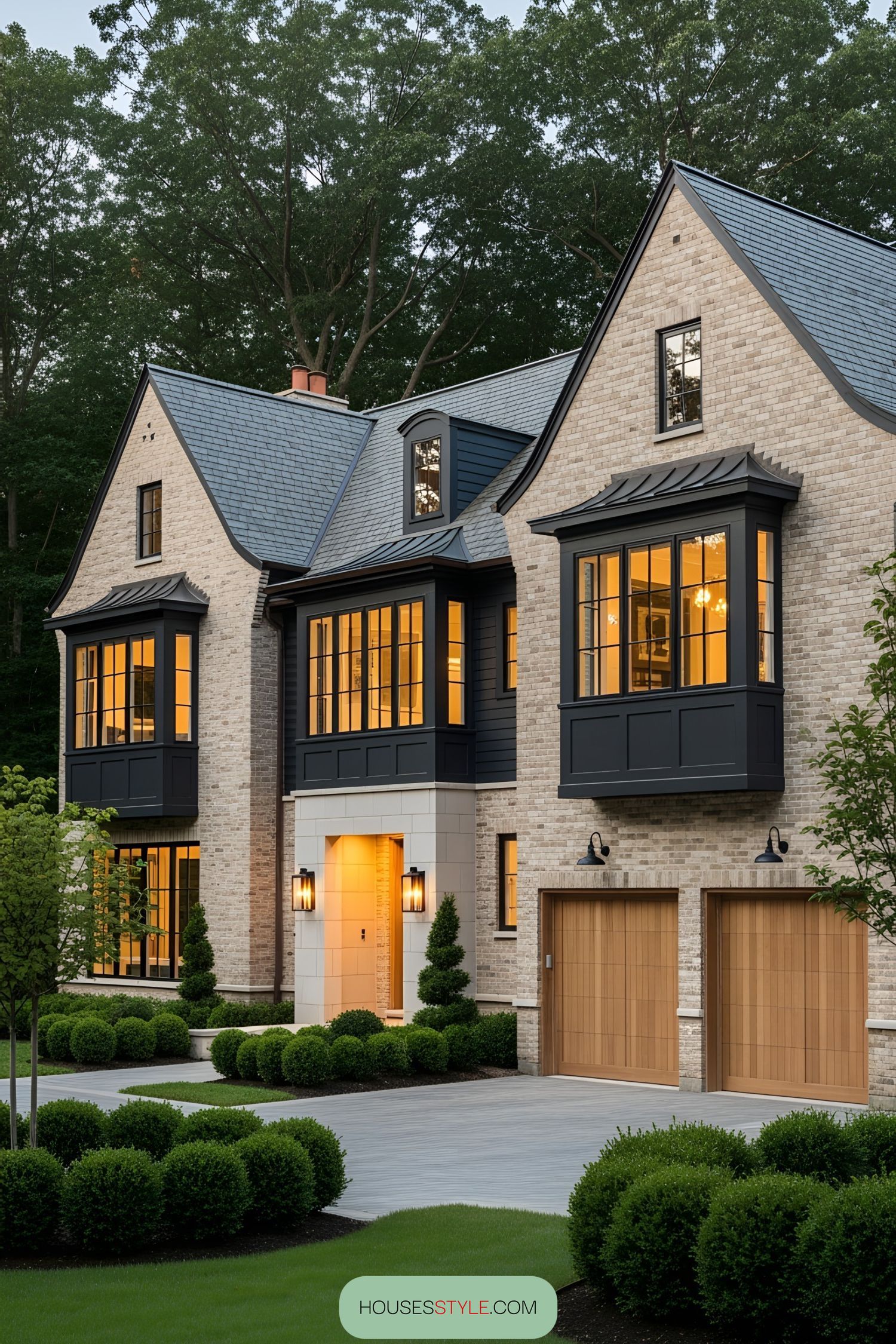 Elegant brick house with gabled roofs and large glowing windows