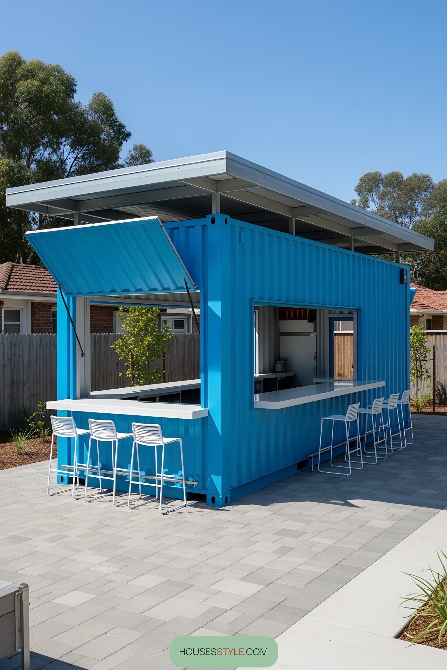 Bright blue container bar with white stools and a modern roof