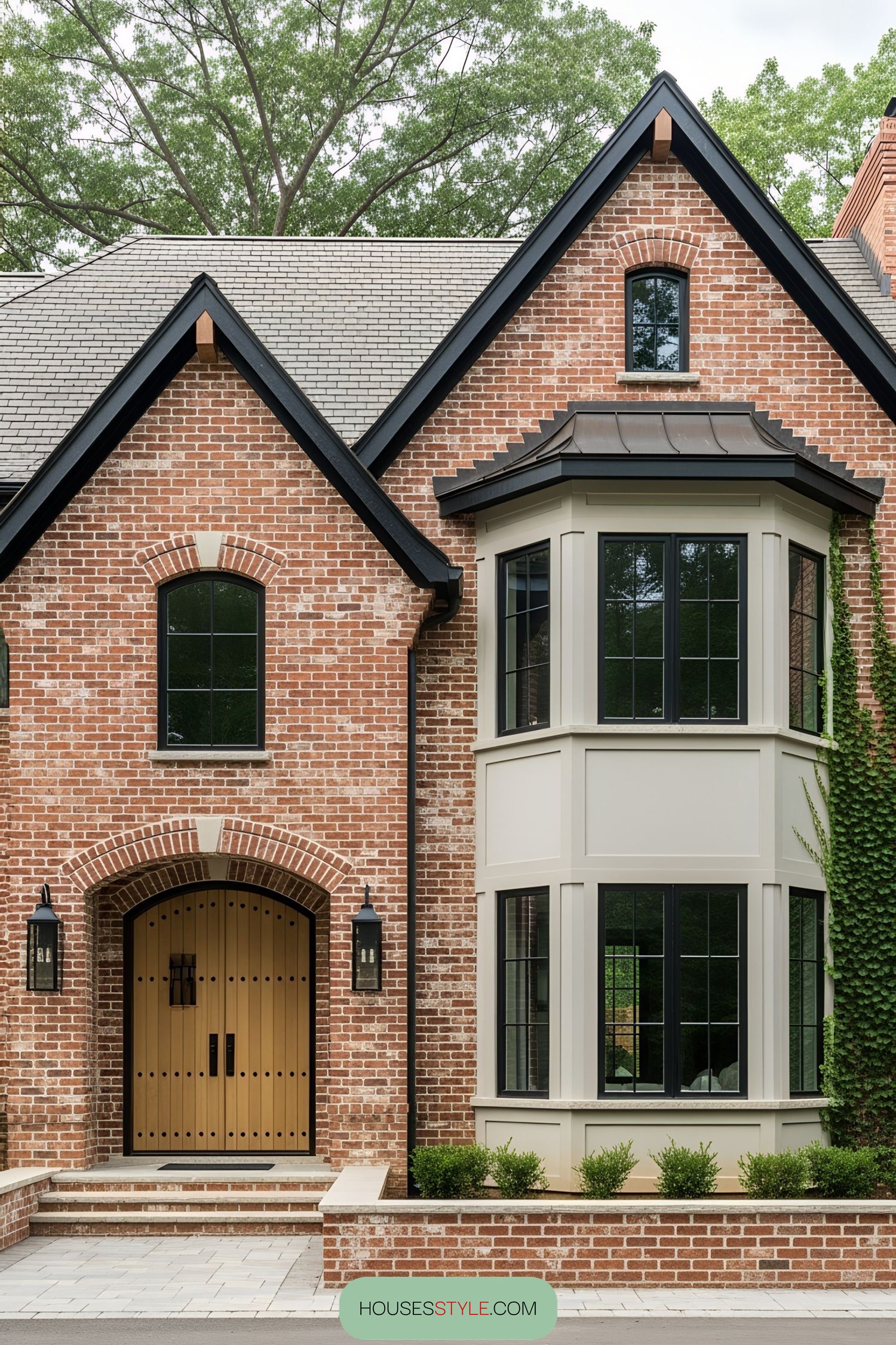 Elegant brick farmhouse with bay windows and arched doorway