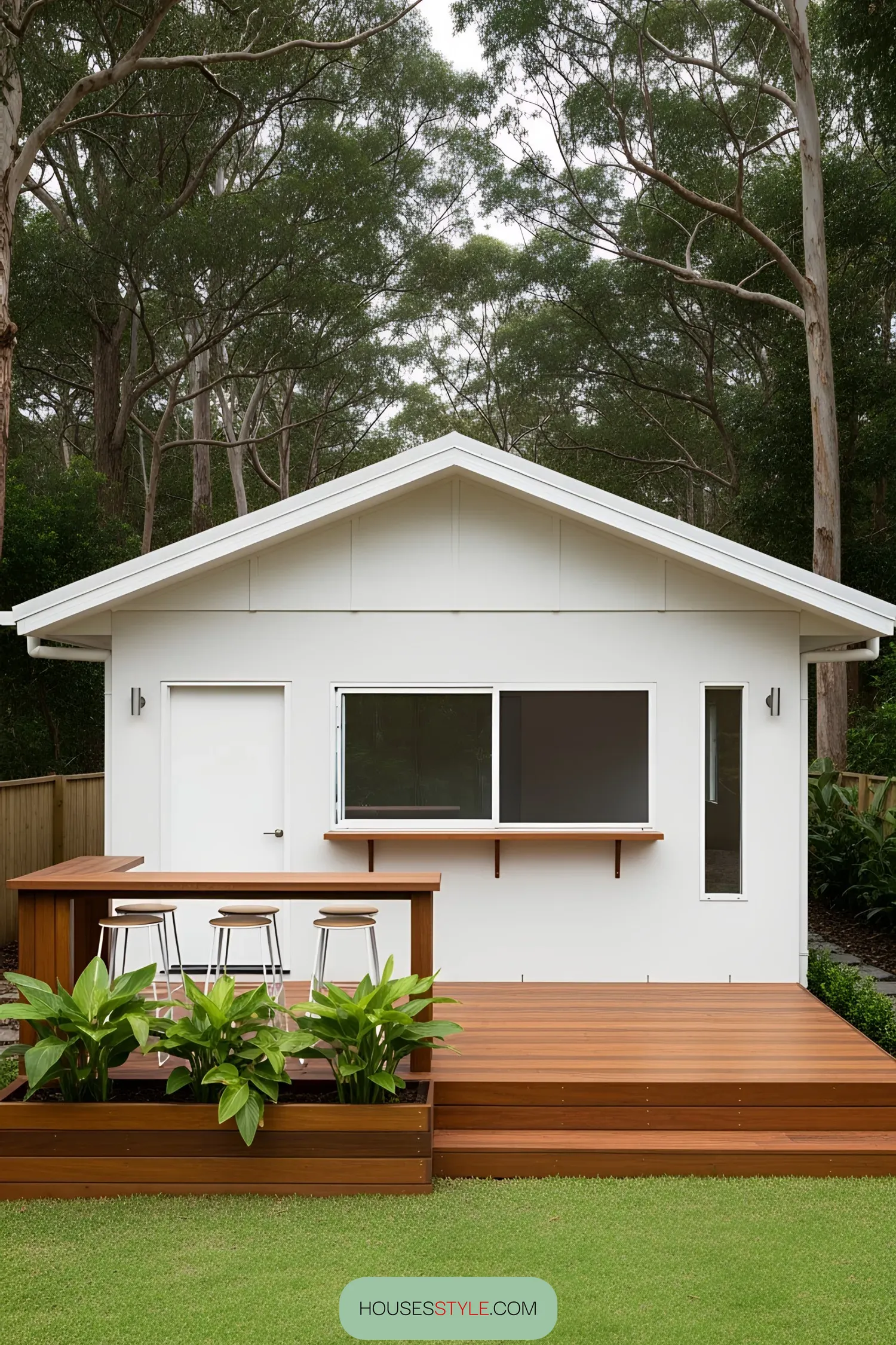 Small white coastal house with a wooden deck
