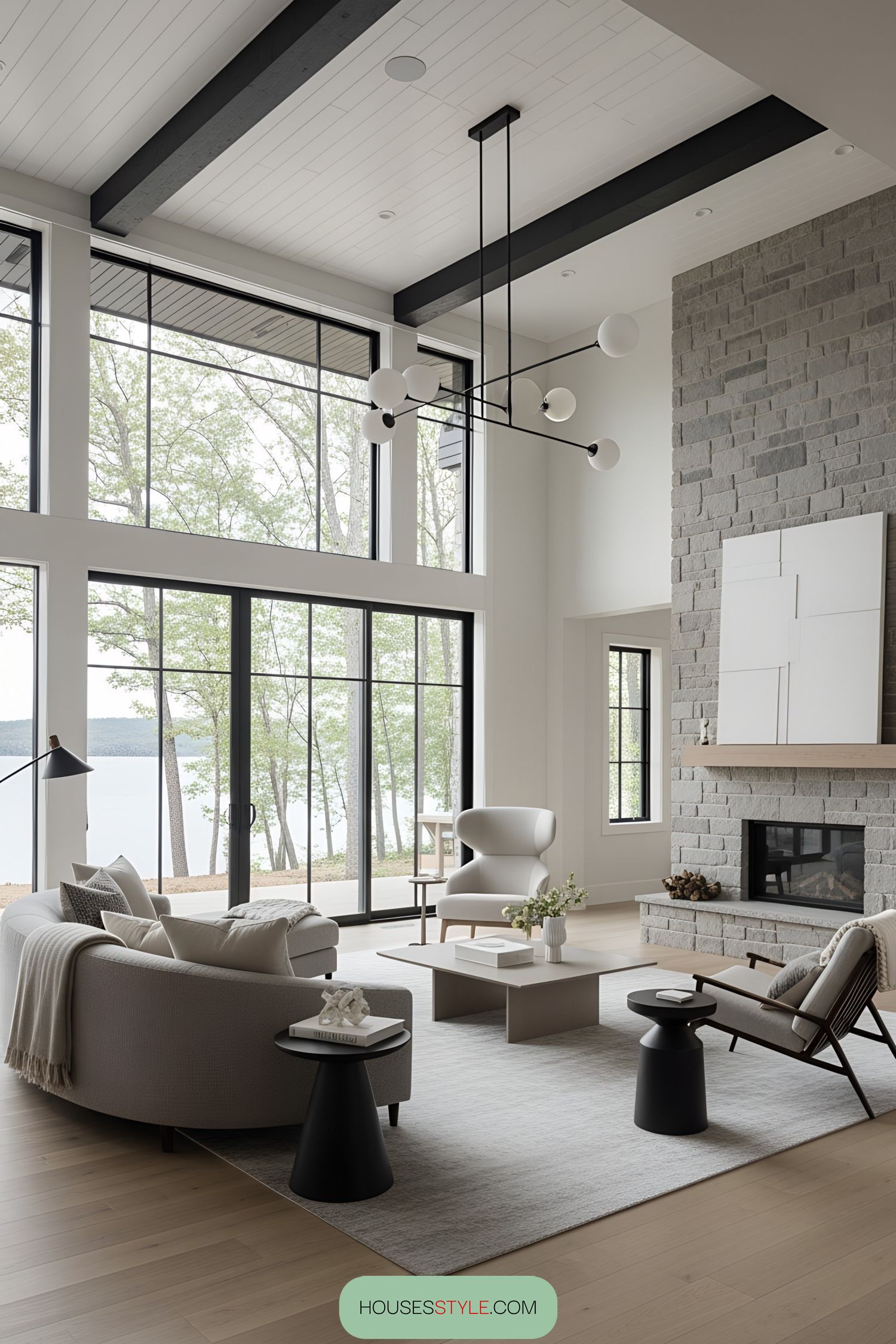 Modern lake house interior with stone fireplace and large windows