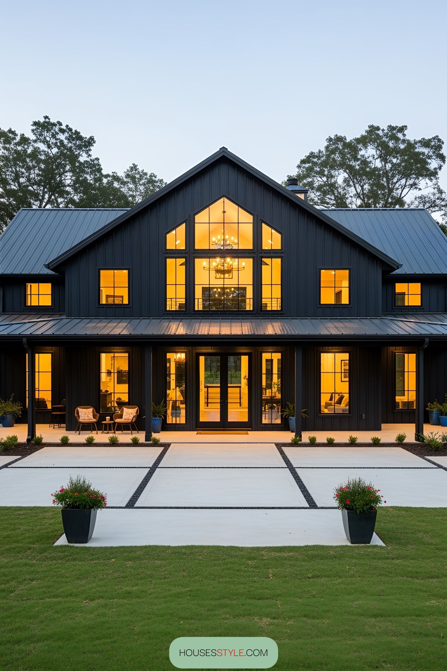 Black barn house with illuminated windows and a modern facade