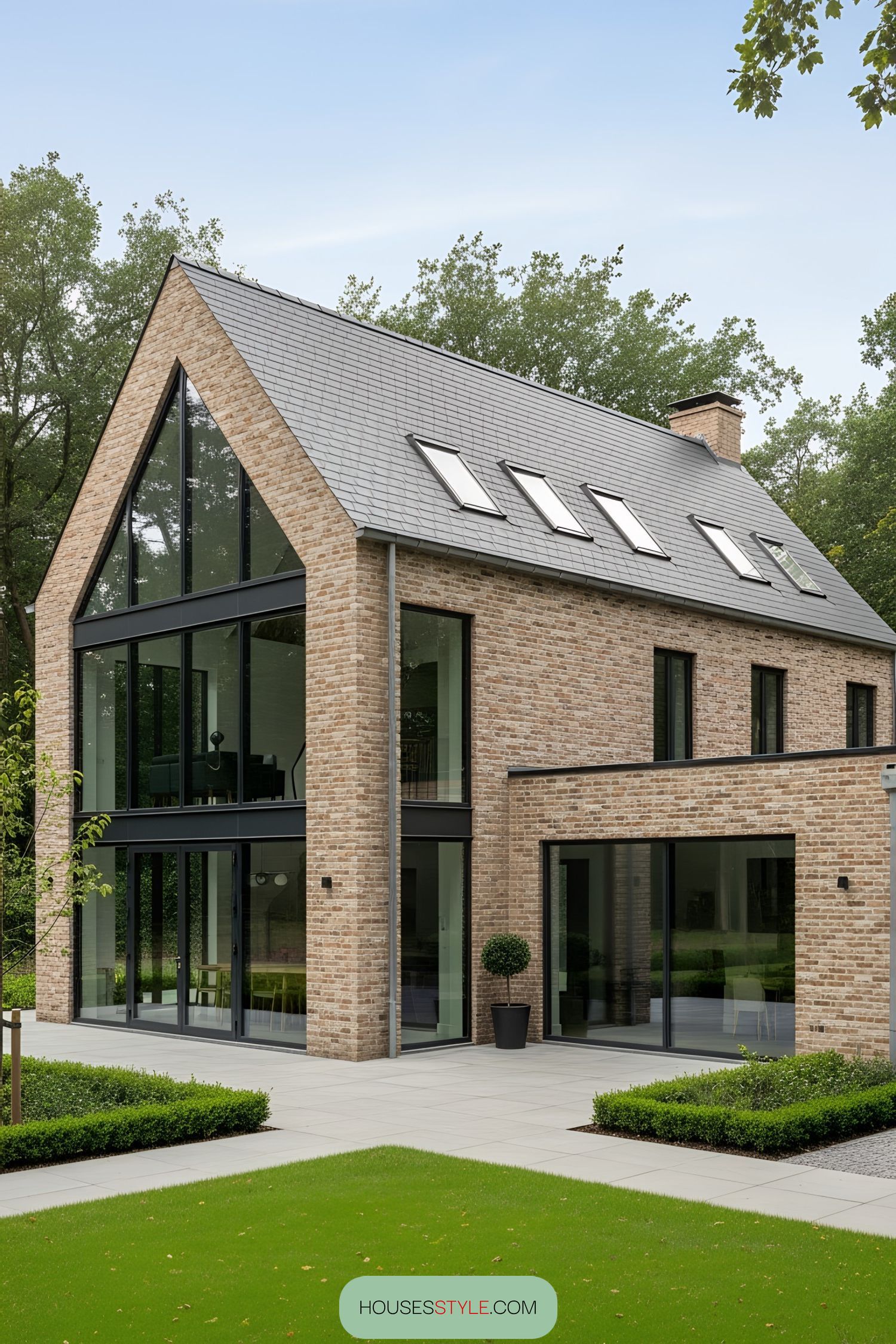 Modern brick farmhouse with large windows and a manicured lawn