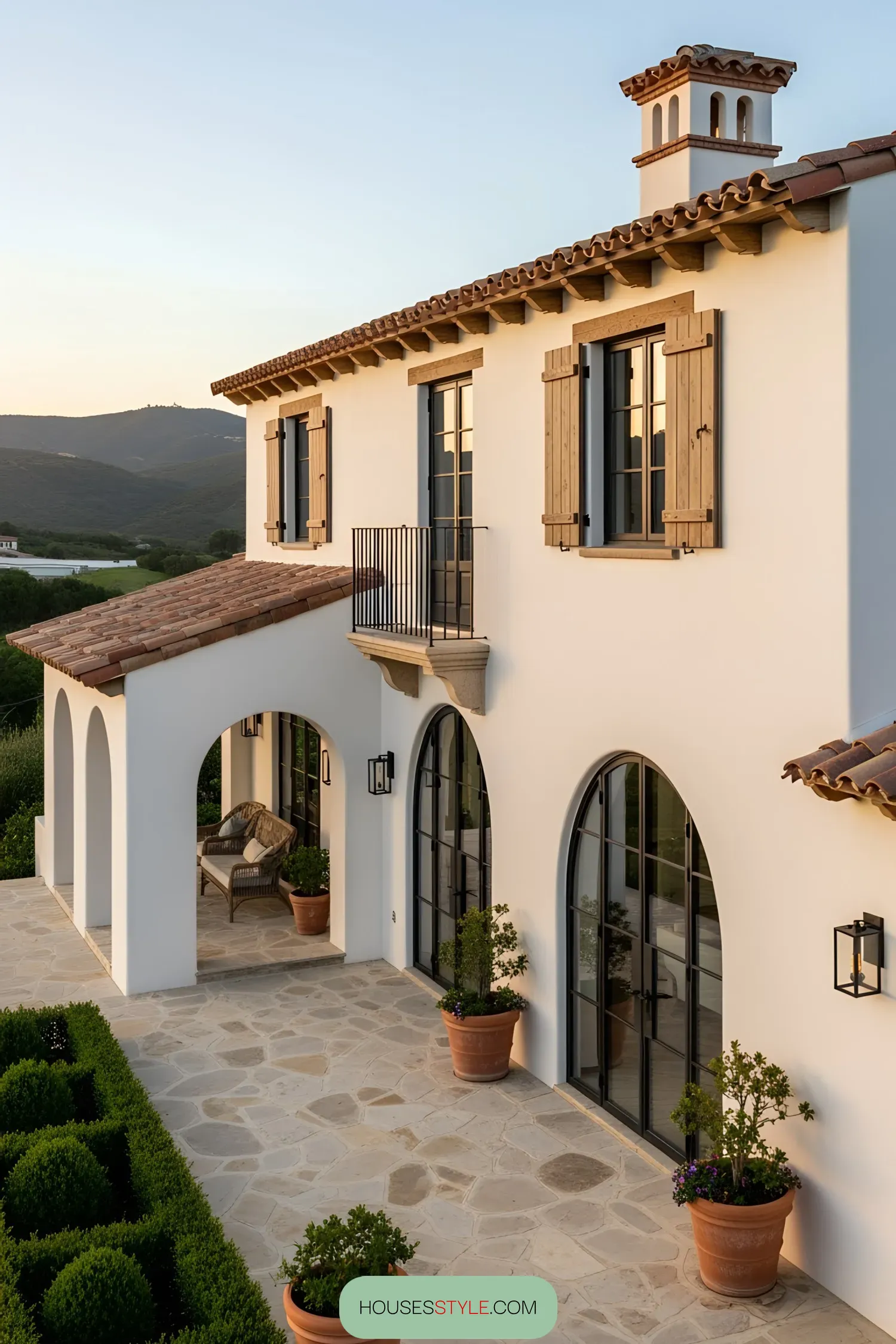 Elegant coastal house with arched windows and terracotta roof