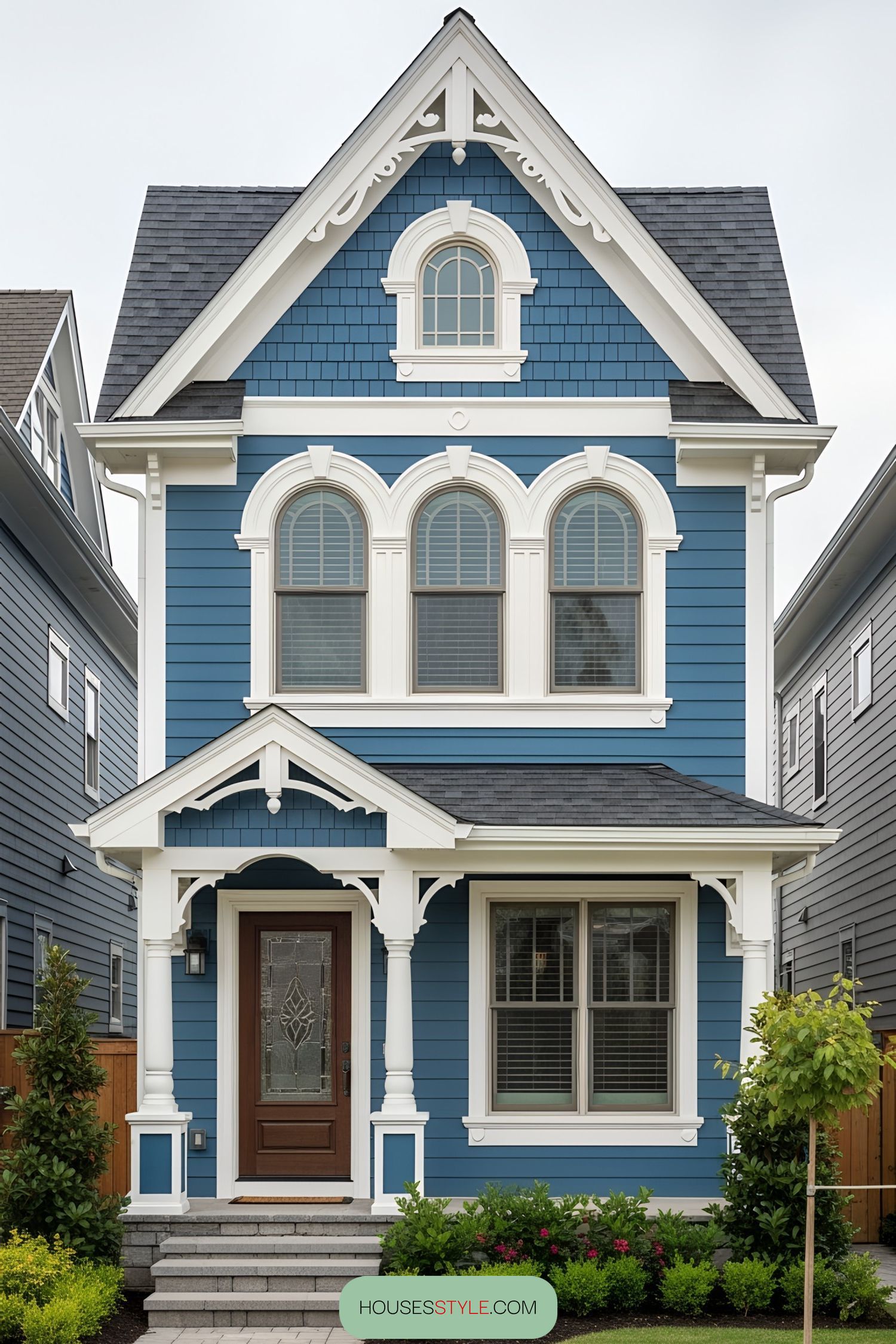 Blue Victorian tiny house with white trim and arched windows