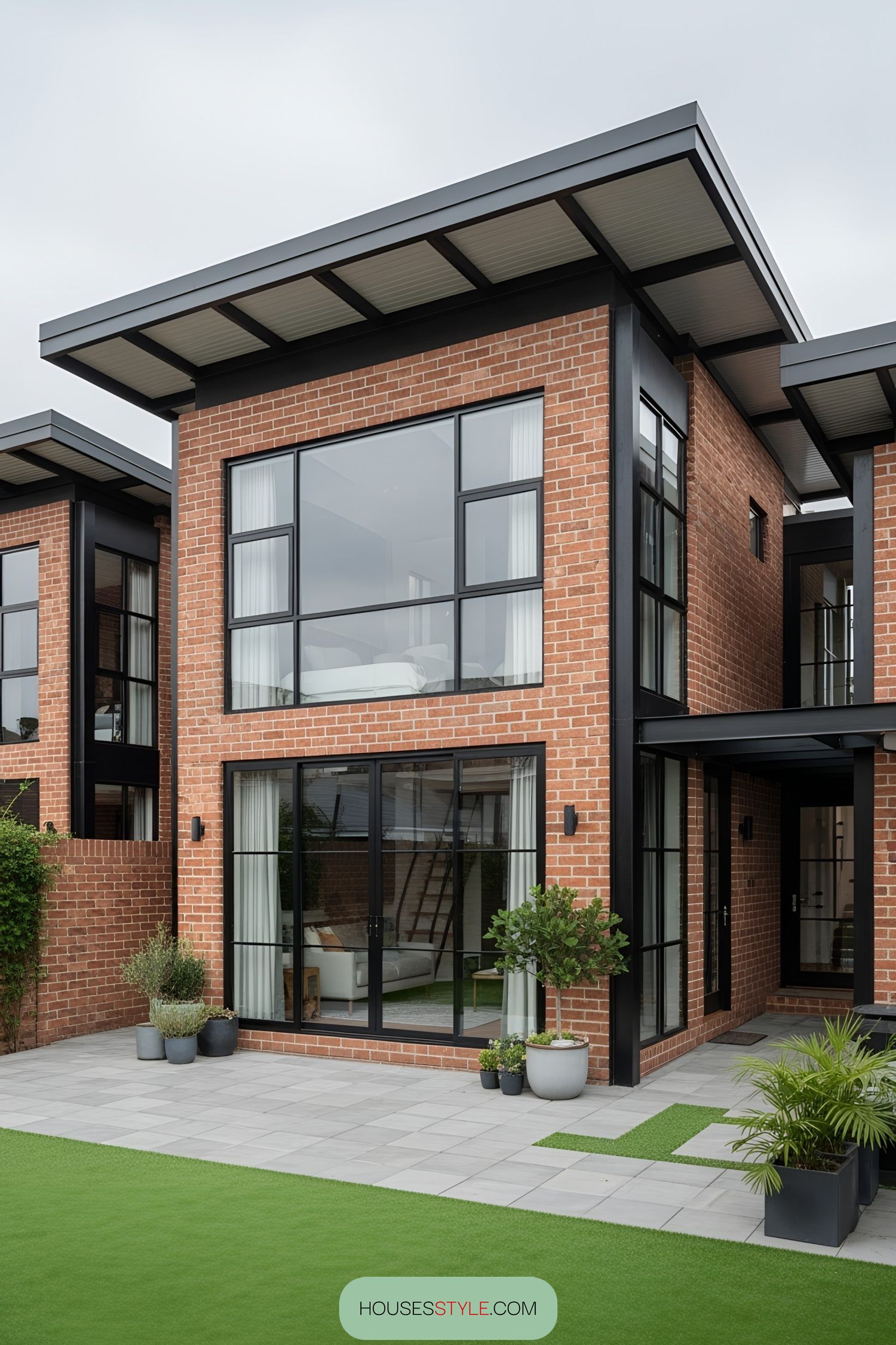 Red brick industrial house with large windows and sleek design