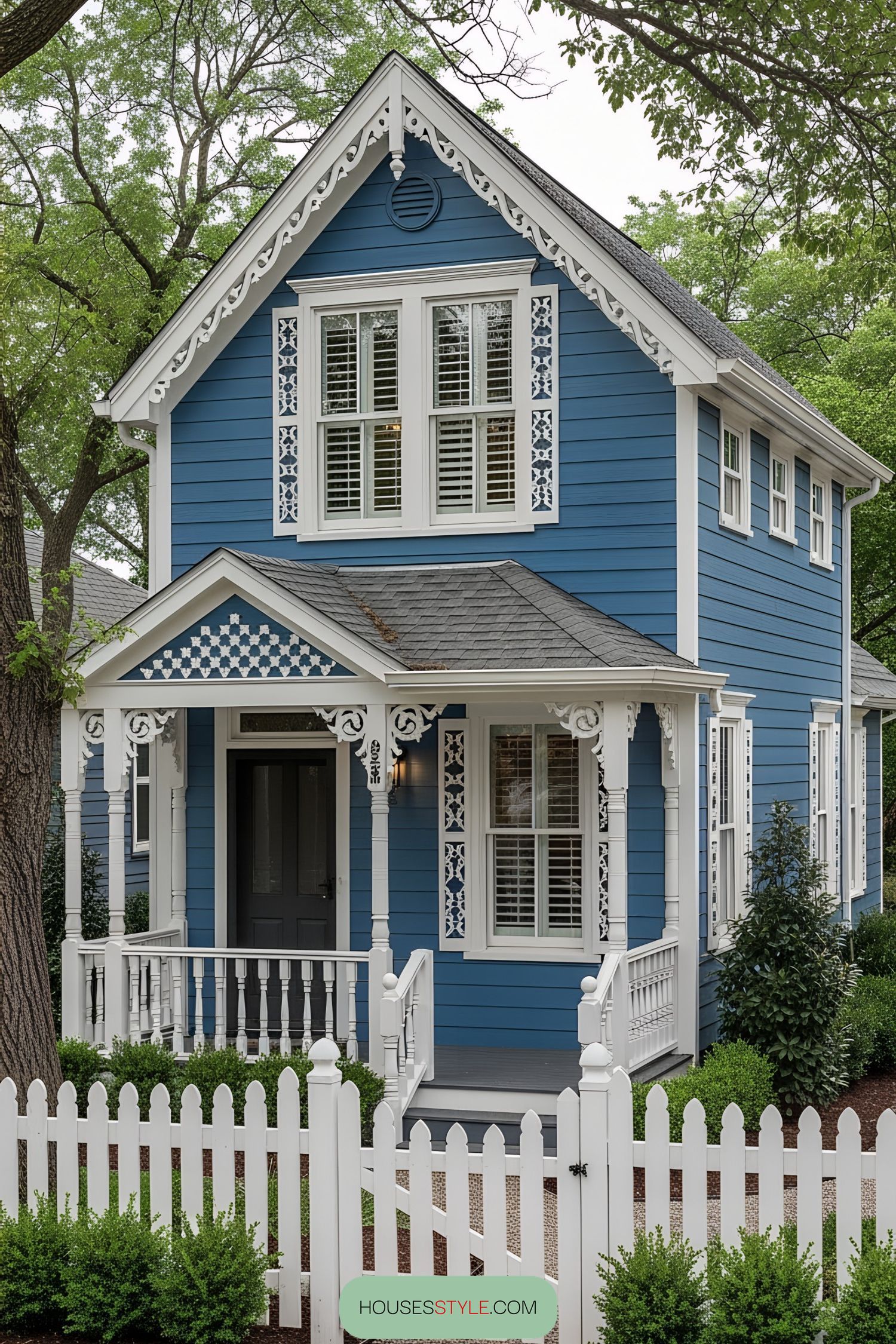 Charming blue Victorian tiny house with intricate white trim