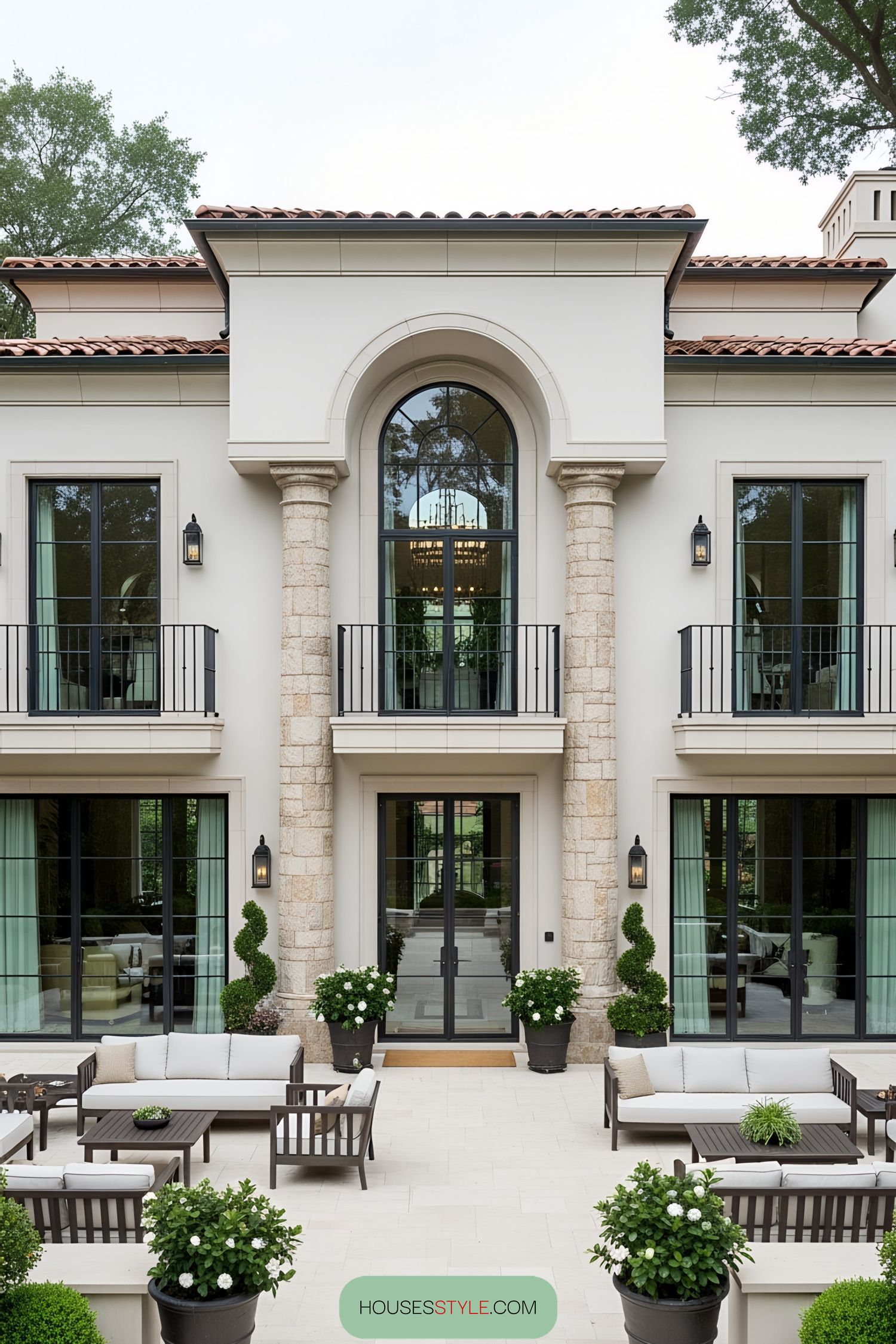 Elegant luxury villa with stone columns and lush courtyard
