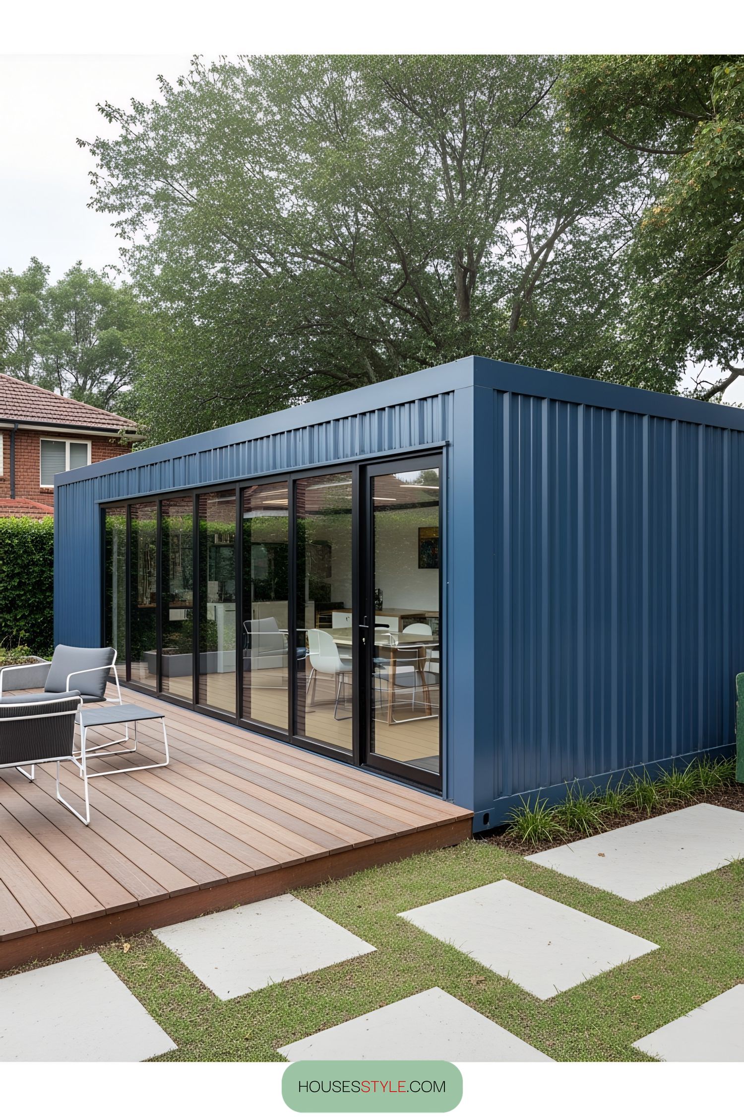 A blue container office with glass doors and a wooden deck