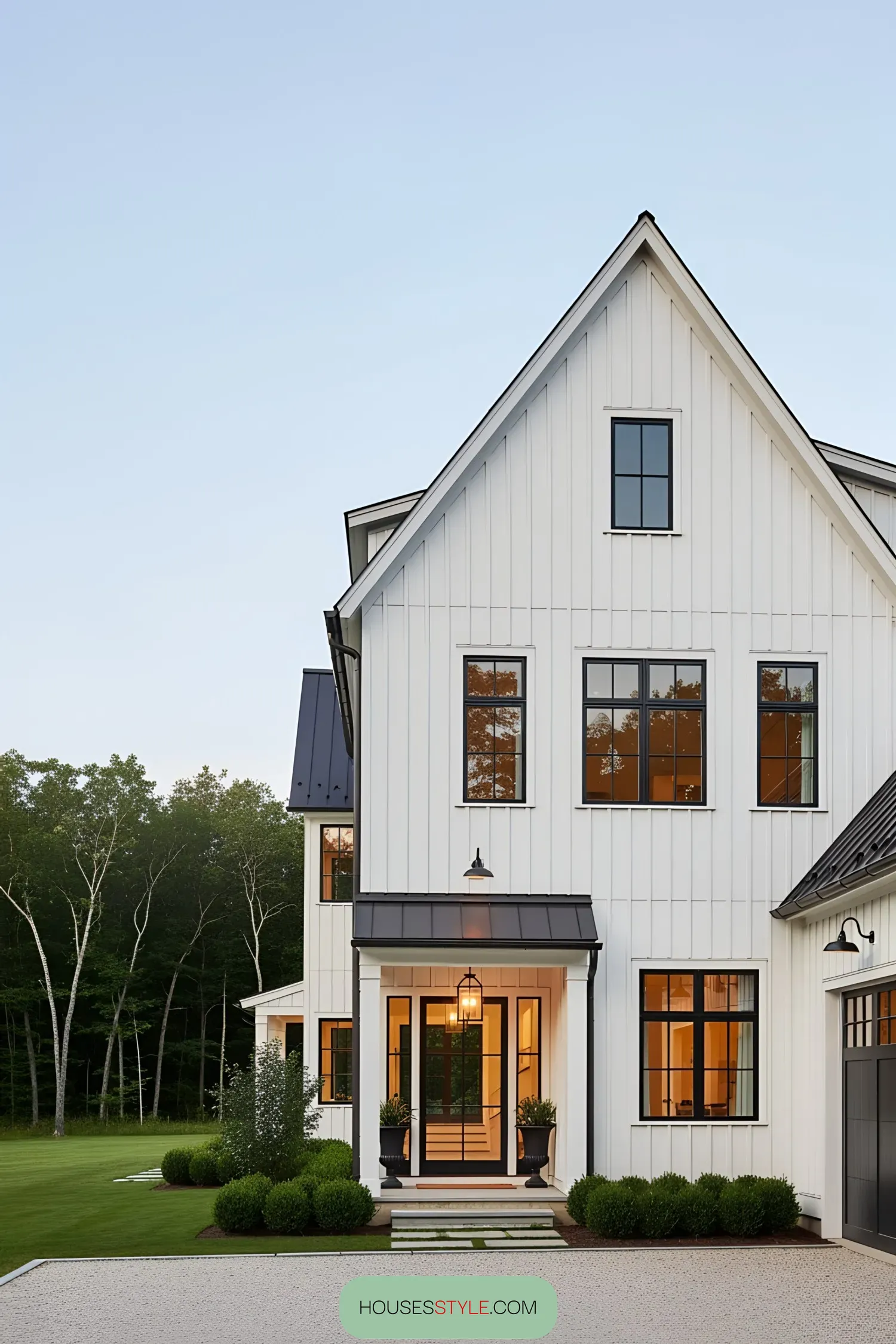 White farmhouse with black-trimmed windows and matching garage