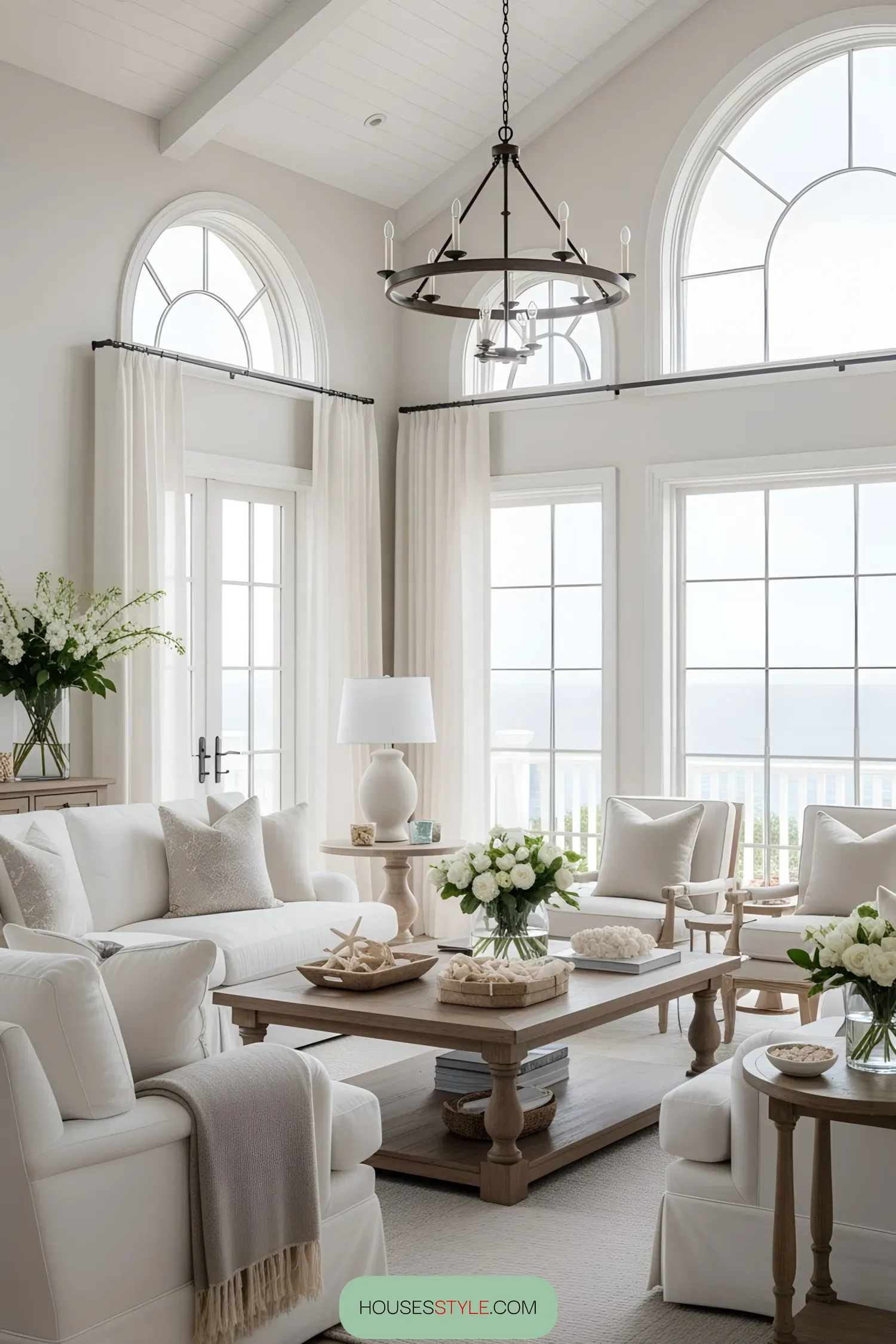 Bright and airy beach house living room with large windows and white furnishings