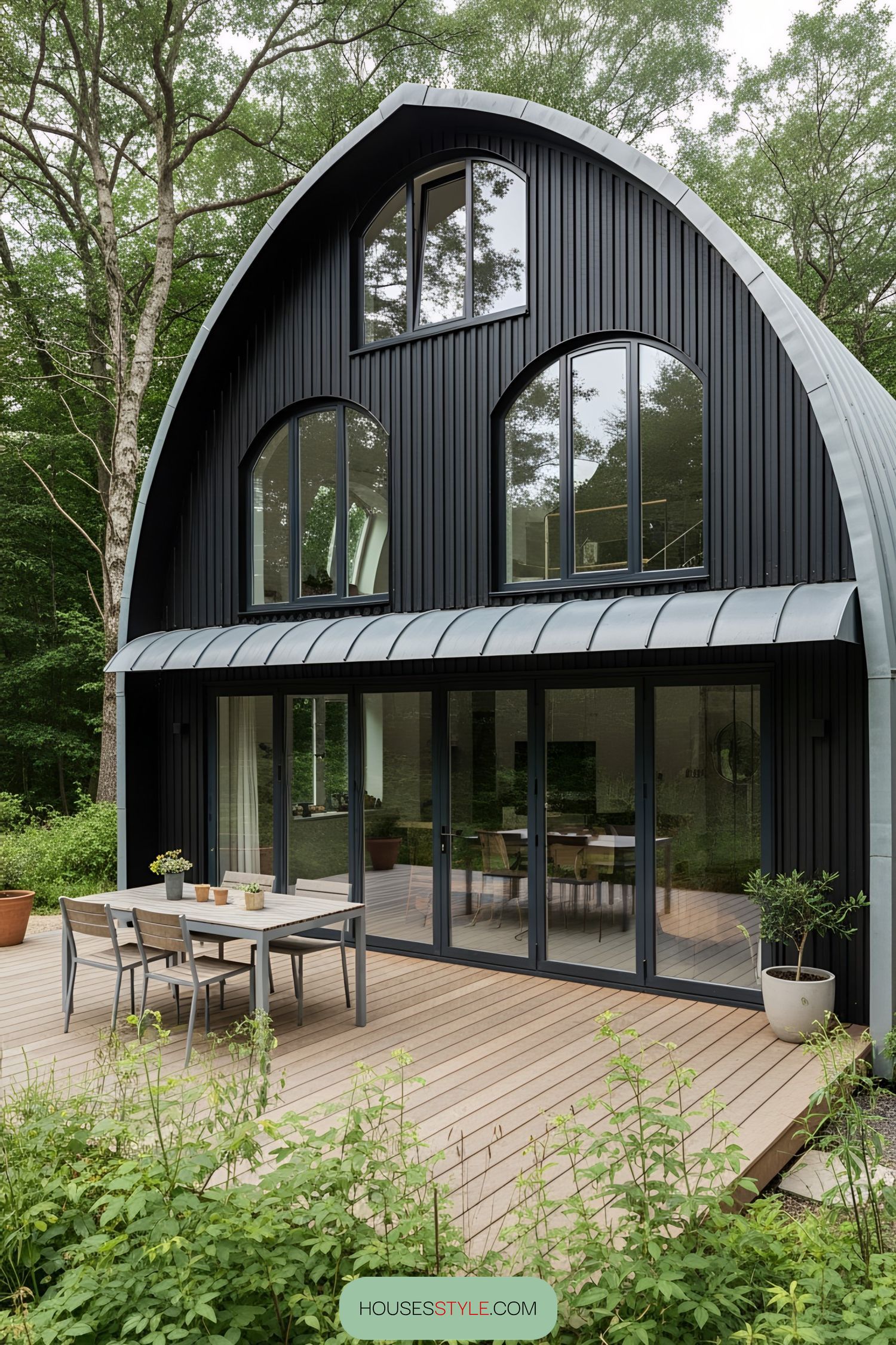 Modern black house with large windows and a curved roof