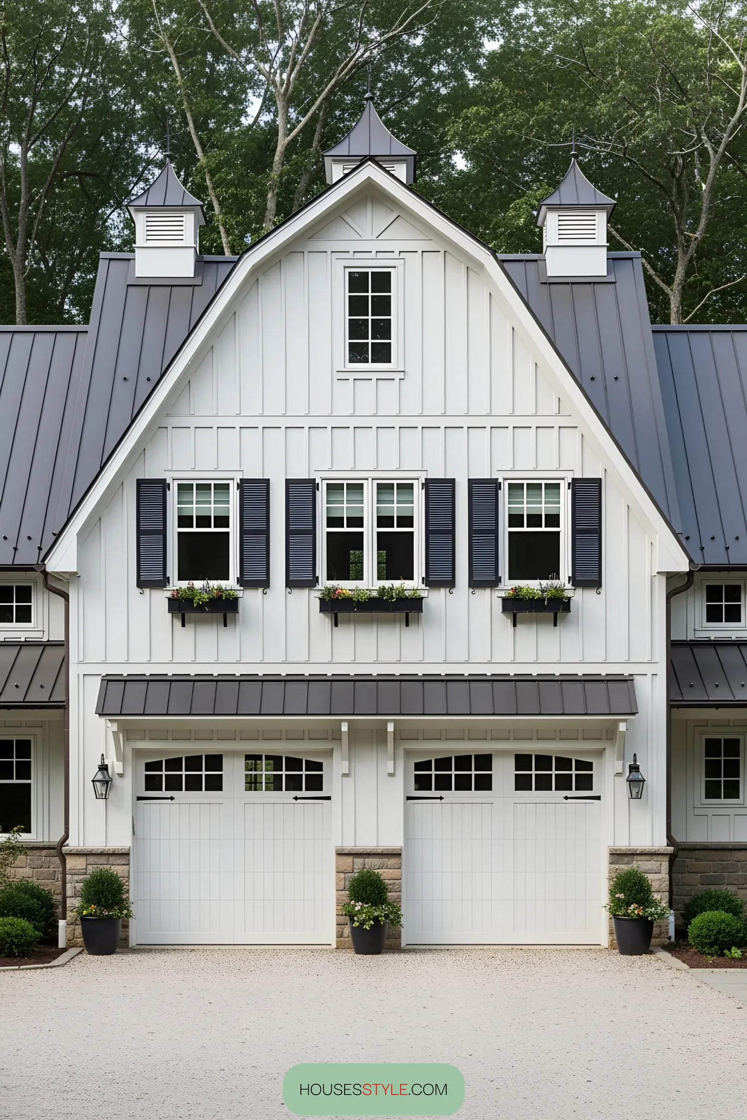White farmhouse with large garage and black shutters