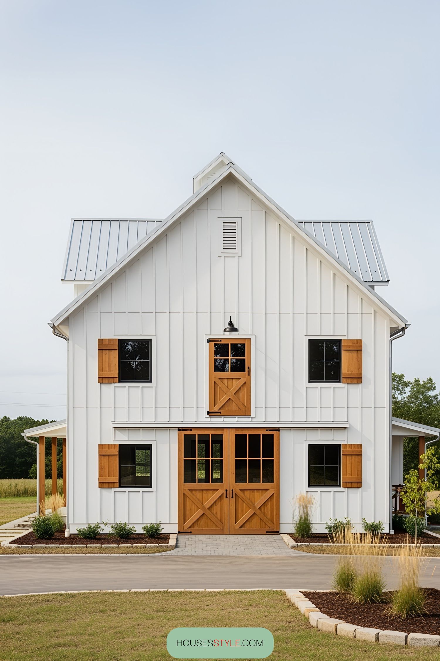 White barn house with wooden accents and metal roof