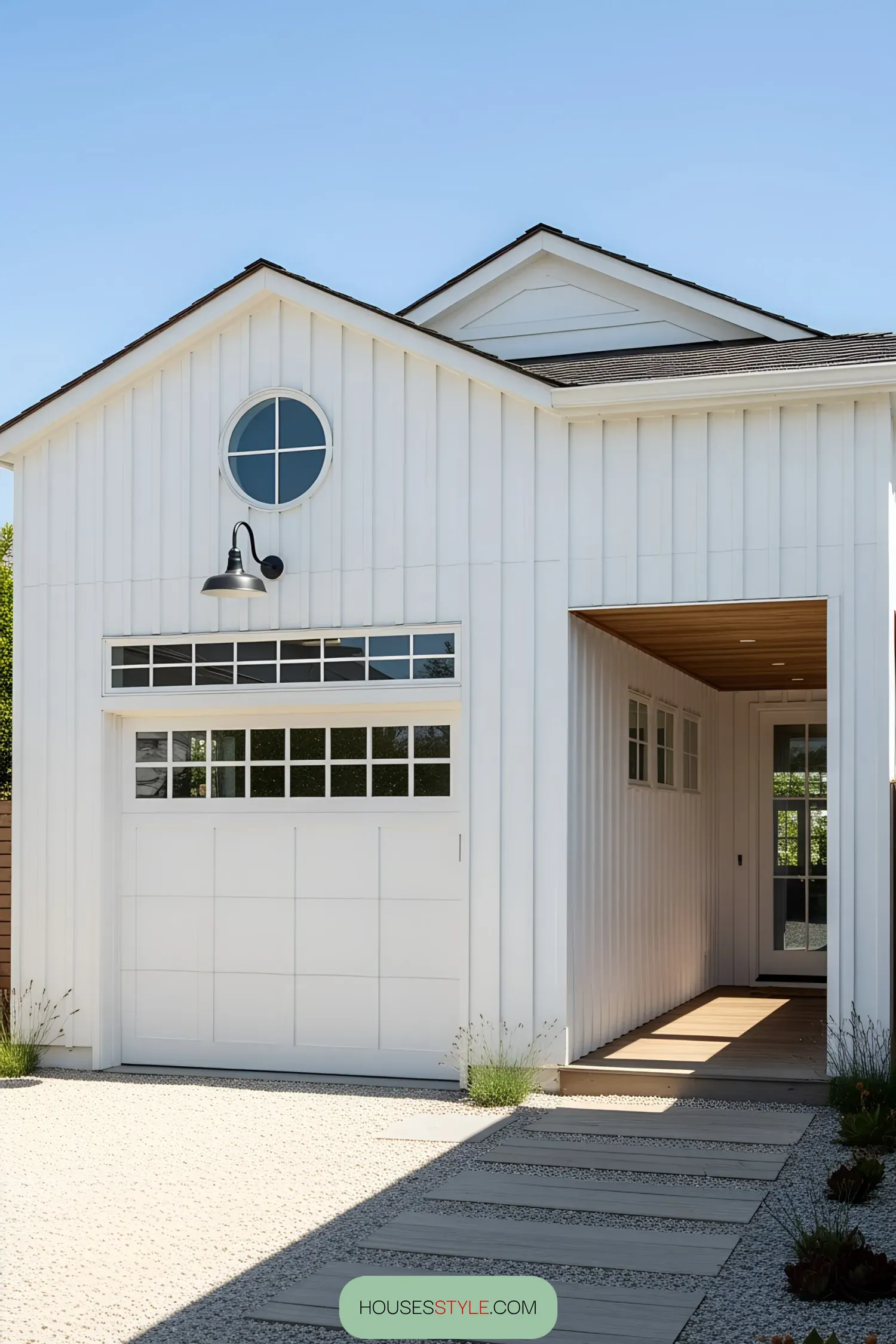 Modern white coastal home with large garage door and pathway