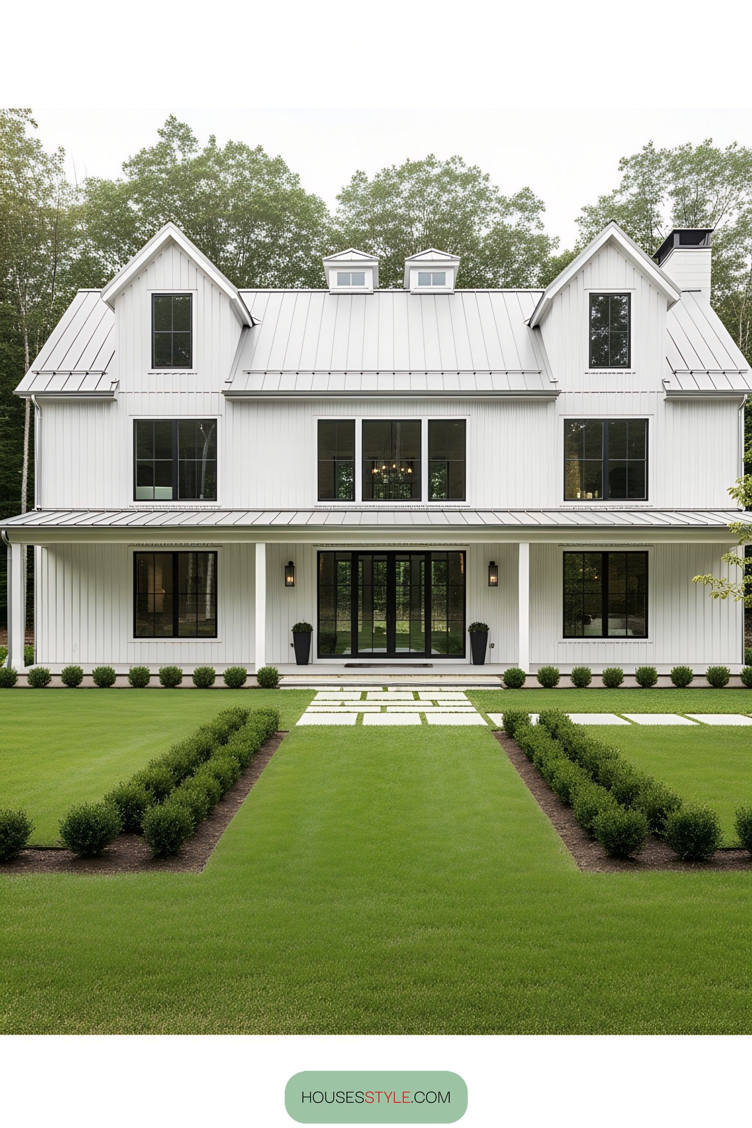 White barn house with manicured lawn and big windows