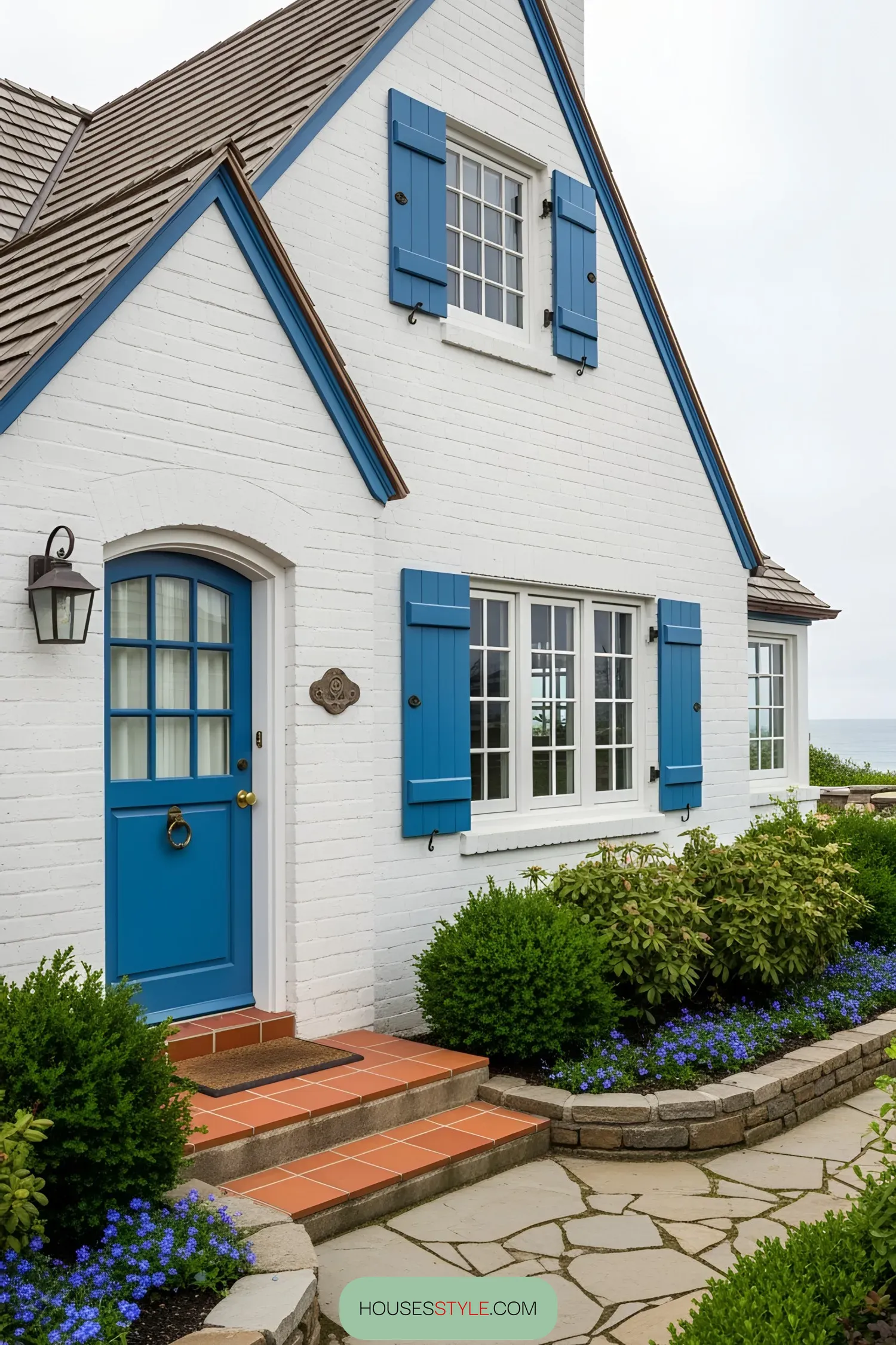 White coastal house with vibrant blue shutters and door