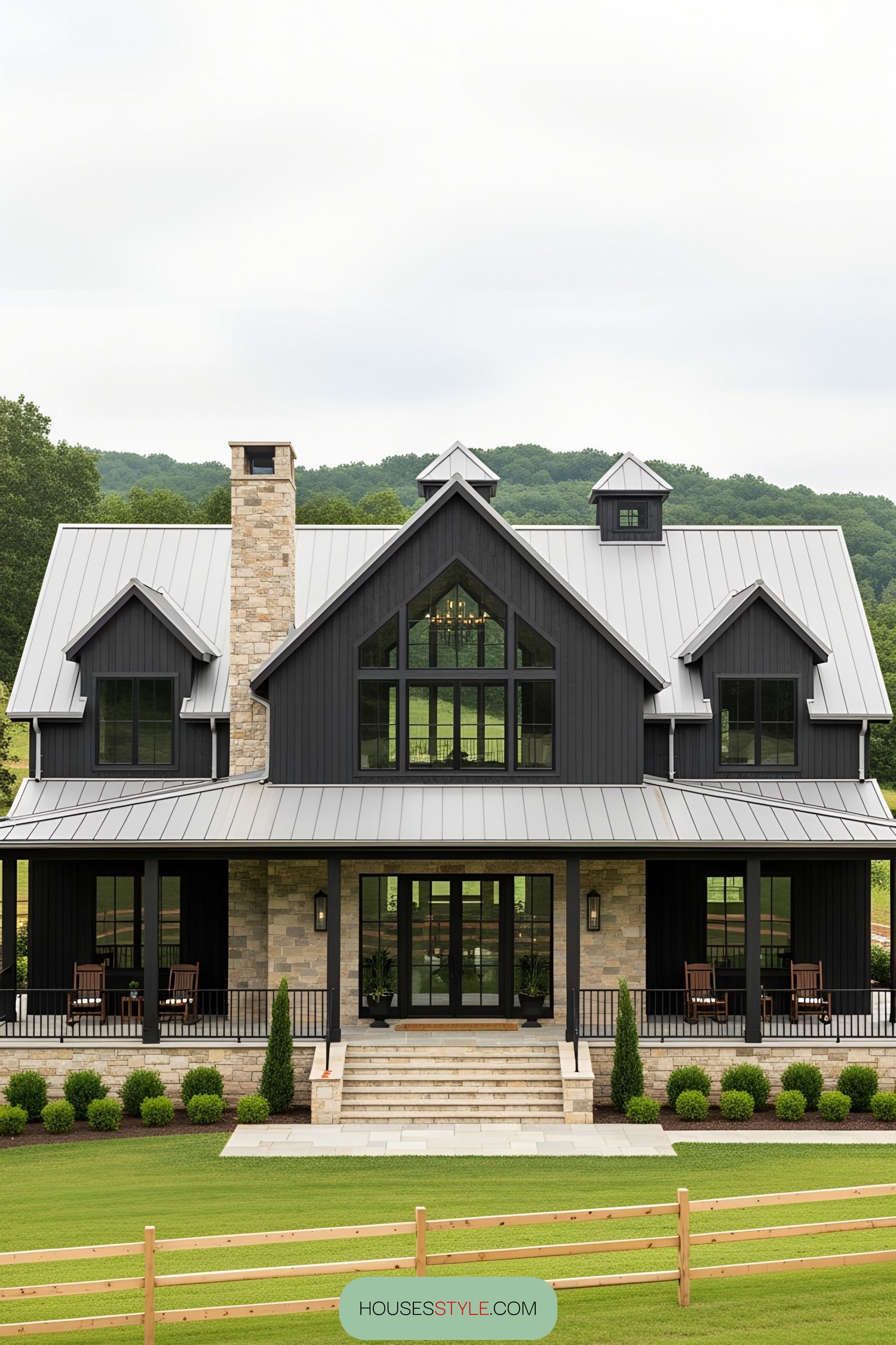 A modern barnhouse with a wraparound porch and lush surroundings