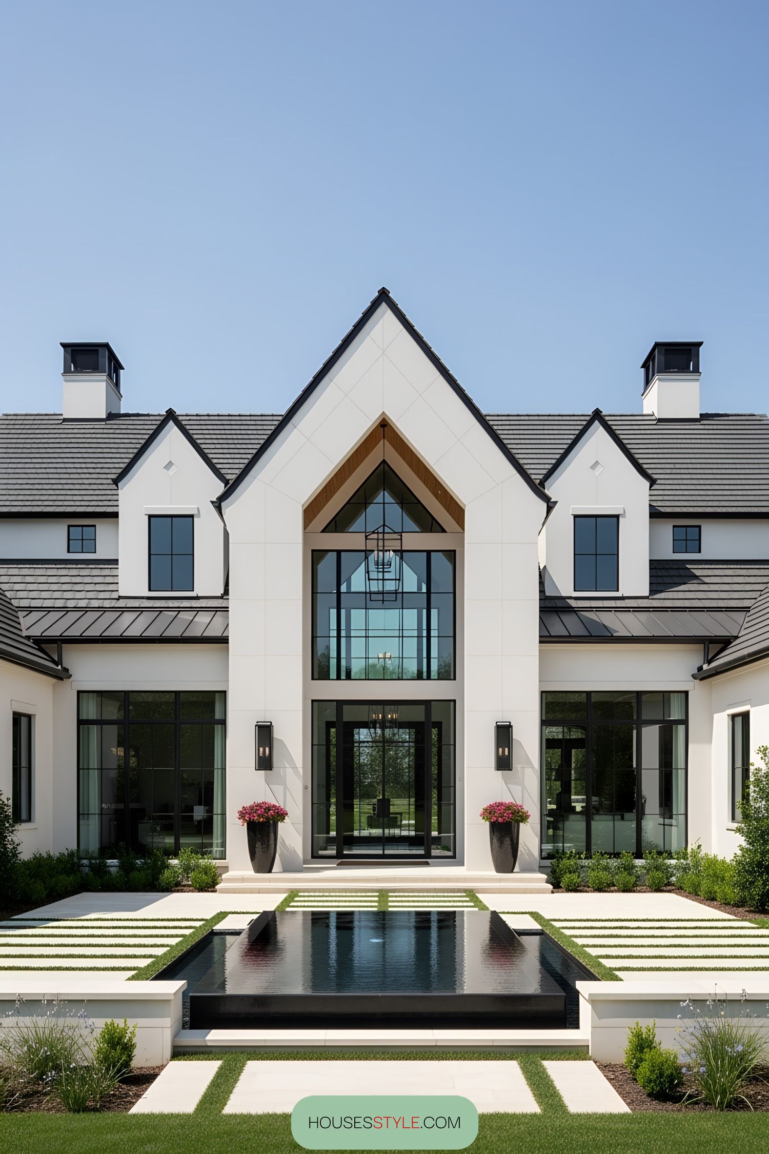Elegant one-story home with sleek glass windows and a beautiful water feature in front